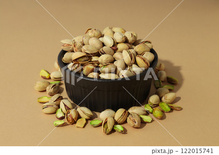 Pistachios in a plate, on a beige background. 122015741
