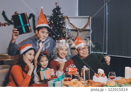 Happy family with gifts celebrating Christmas together Happy family with gifts celebrating Christmas together 122015814
