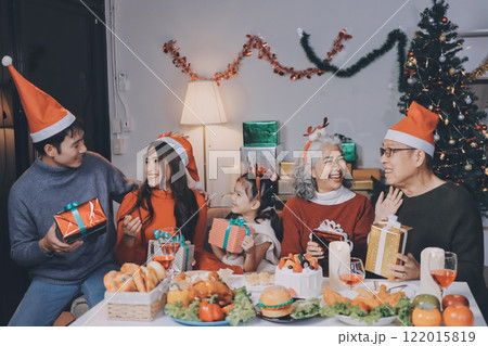 Happy family with gifts celebrating Christmas together Happy family with gifts celebrating Christmas together 122015819