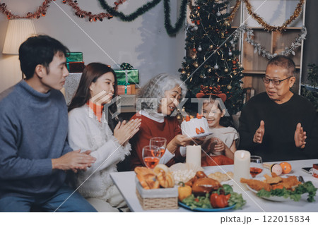 Multi-Generation Family Celebrate Christmas At Home Wearing Santa Hats And Antlers Opening Presents Multi-Generation Family Celebrate Christmas At Home Wearing Santa Hats And Antlers Opening Presents 122015834