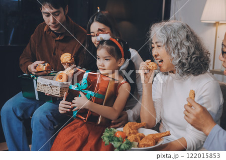 Portrait of Asian family exchanging presents during christmas at home. Attractive happy people holding gift box, celebrate holiday thanksgiving, xmas eve tradition in living room in house together. 122015853
