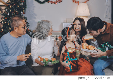 Portrait of Asian family exchanging presents during christmas at home. Attractive happy people holding gift box, celebrate holiday thanksgiving, xmas eve tradition in living room in house together. Portrait of Asian family exchanging presents during christmas at home. Attractive happy people holding gift box, celebrate holiday thanksgiving, xmas eve tradition in living room in house together. 122015856
