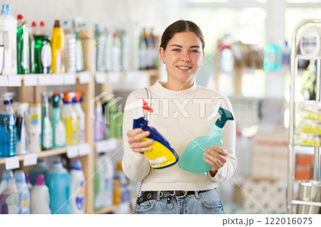 Woman choosing a cleaning spray Woman choosing a cleaning spray 122016075