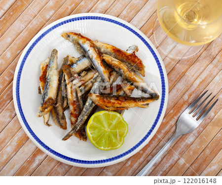 Fried anchovies with lemon on a plate Fried anchovies with lemon on a plate 122016148