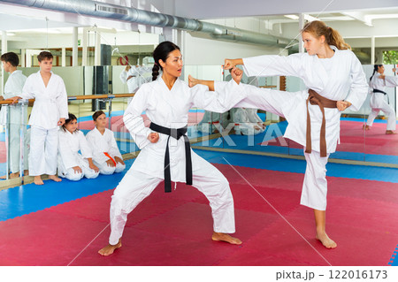 Teenager girl practicing taekwondo kicks Teenager girl practicing taekwondo kicks 122016173