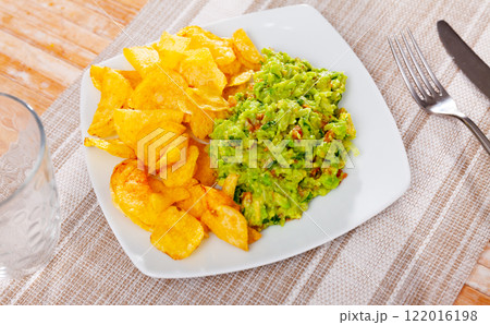 Plate of mexican chips with guacamole and glass beer closeup 122016198