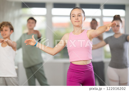 Teenage girl practicing ballet positions in dance studio 122016202