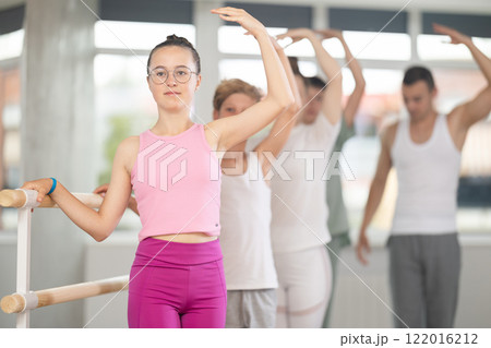 Teenage girl practicing ballet positions in dance studio Teenage girl practicing ballet positions in dance studio 122016212