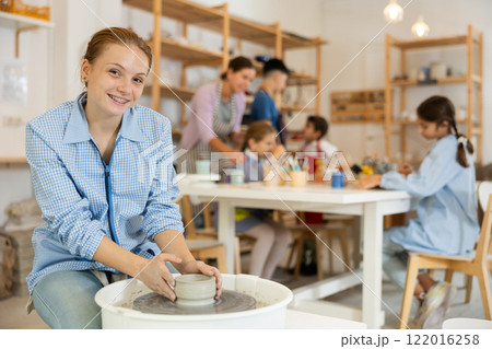 Girl working at a potter's wheel Girl working at a potter's wheel 122016258