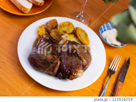 Roasted pork cheeks with baked potatoes and sauce 122016259