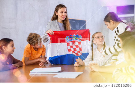 Female teacher working with students in school class, talking about national flag of Croatia at history lesson 122016296