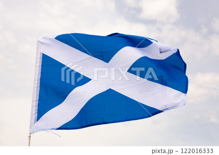Against background of cloudy sky, flag of Scotland flutters on flagpole Against background of cloudy sky, flag of Scotland flutters on flagpole 122016333