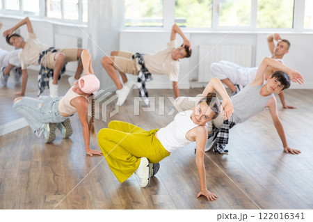 Teenage girl dancing breakdancing in group Teenage girl dancing breakdancing in group 122016341