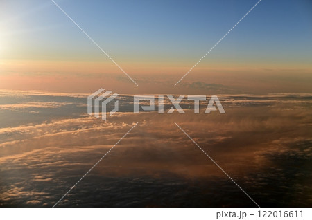 飛行機の窓から眺める夕日に染まり始める雲海 飛行機の窓から眺める夕日に染まり始める雲海 122016611
