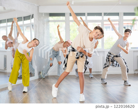 Teenagers in casual clothes are training together to dance hip-hop and breakdancing in dance center 122016620