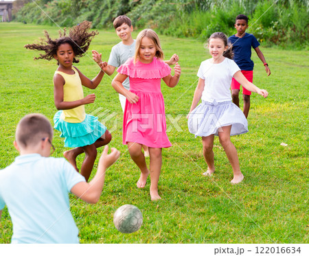 Group of kids playing football on grass 122016634