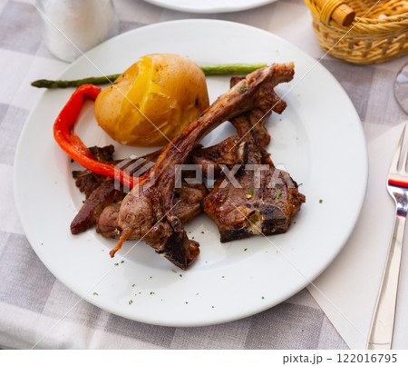 Lamb ribs served with potatoes and peppers 122016795