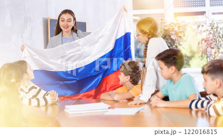 Teacher showing Russia flag to group of schoolchildren Teacher showing Russia flag to group of schoolchildren 122016815