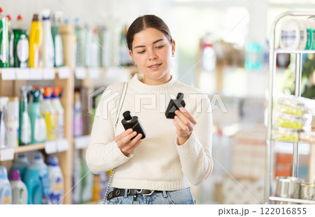 Young woman client sniffs fragrance of perfume, chooses scent spray with pleasant smell 122016855