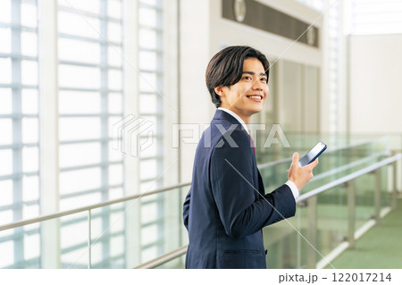 ロビーでスマホを使う若いビジネスマン 122017214