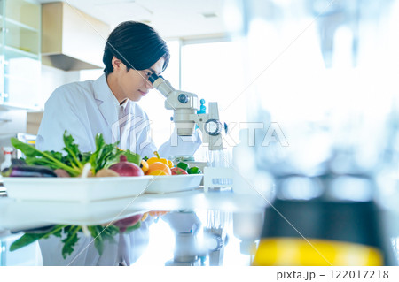 顕微鏡で野菜の成分を観察する若い研究者 管理栄養士 顕微鏡で野菜の成分を観察する若い研究者 管理栄養士 122017218
