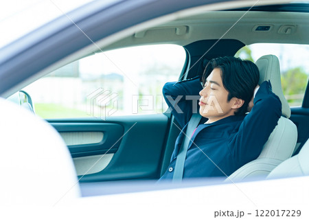 自動車の車内で眠るドライバー　自動運転　休憩　車中泊 122017229