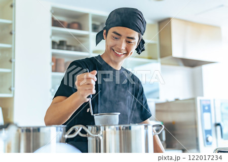 厨房で麺を茹でる飲食店店員 厨房で麺を茹でる飲食店店員 122017234