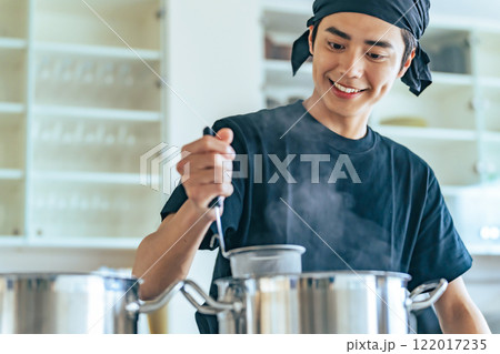厨房で麺を茹でる飲食店店員 厨房で麺を茹でる飲食店店員 122017235