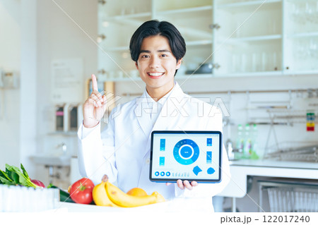 タブレットで画面を見せながら説明する研究者 122017240