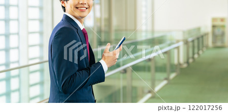 ロビーでスマホを使う若いビジネスマン 122017256