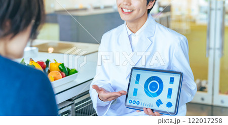 タブレット画面を見せて説明する白衣の男性 122017258