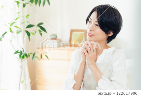 リビングで考えるエプロン姿の女性 122017900