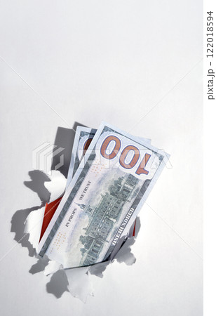 Dollar banknotes cash from the hole of ripped paper. Mockup or Copy space. Concept of business or finance Dollar banknotes cash from the hole of ripped paper. Mockup or Copy space. Concept of business or finance 122018594