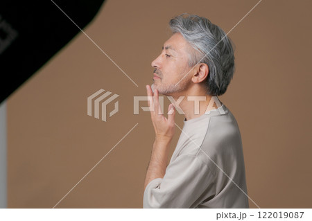 顎に手を当てるシニア男性 122019087
