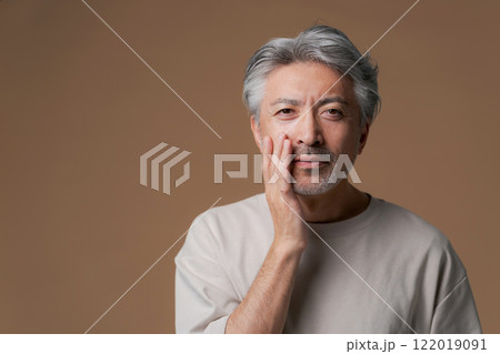 顎に手を当てるシニア男性 122019091