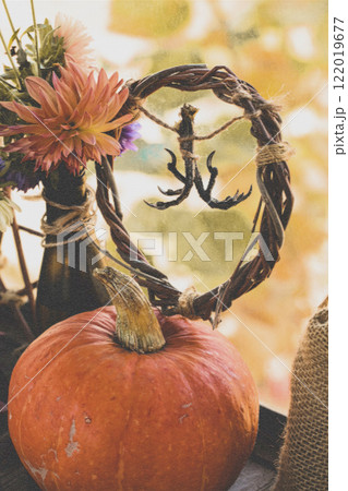 Pagan home autumn altar. Dry birds claws, pumpkin, willow wreath, flowers and canvas bag as a set, vertical format. 122019677