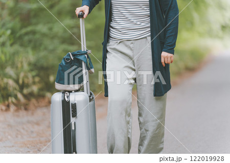山道でスーツケースを転がす観光客 山道でスーツケースを転がす観光客 122019928