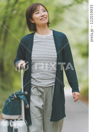 山道でスーツケースを転がす観光客 122019935