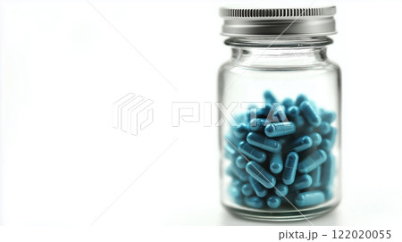 Glass jar filled with blue medical capsules against white background, featuring metallic screw cap and soft focus edges, demonstrating pharmaceutical product presentation. Healthcare supplement Glass jar filled with blue medical capsules against white background, featuring metallic screw cap and soft focus edges, demonstrating pharmaceutical product presentation. Healthcare supplement 122020055