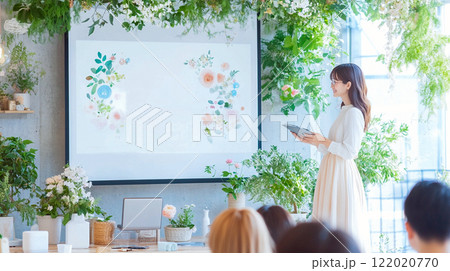 自然光あふれる室内でのプレゼンテーションをする若い女性 - ナチュラル 122020770