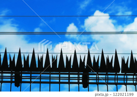 鉄道の柵上のステンレス アムレット（忍び返し）と青空の風景 122021199