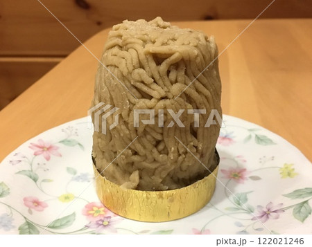 可愛い花柄の皿の上に乗った背の高いモンブランケーキ 122021246