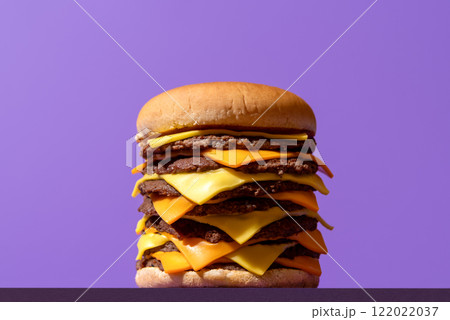 XXL cheeseburger with beef and cheese, isolated on a purple background. XXL cheeseburger with beef and cheese, isolated on a purple background. 122022037