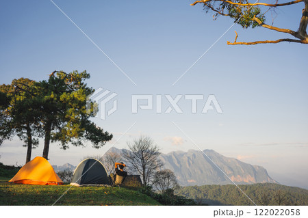 landscape and travel concept with asian man relax see sunset camping tent on mountain landscape and travel concept with asian man relax see sunset camping tent on mountain 122022058