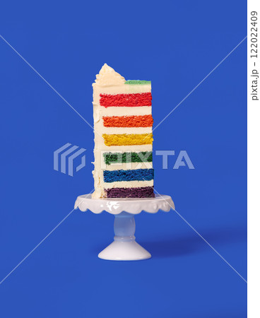 Rainbow cake slice isolated on a blue background. Rainbow cake slice isolated on a blue background. 122022409