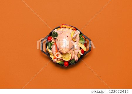 Raw chicken with vegetables, ready to be cooked, in an iron cast, top view Raw chicken with vegetables, ready to be cooked, in an iron cast, top view 122022413