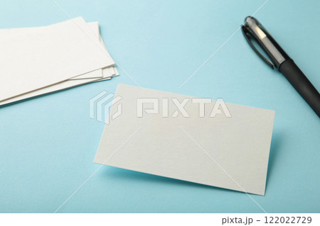 Blank white business cards with pen on blue paper background. Mockup for branding identity. Template for graphic designers portfolios. Blank white business cards with pen on blue paper background. Mockup for branding identity. Template for graphic designers portfolios. 122022729