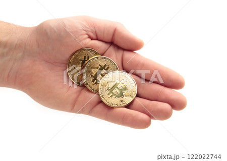Man holds Bitcoin coin on white isolated background. Bitcoin growthand investment concept. Man holds Bitcoin coin on white isolated background. Bitcoin growthand investment concept. 122022744