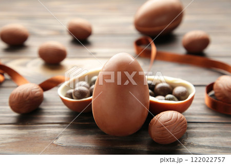 Easter composition with chocolate eggs and brown ribbon on brown background 122022757