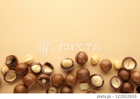 Peeled macadamia nuts on beige background. Top view. Peeled macadamia nuts on beige background. Top view. 122022810